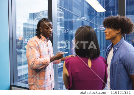 African American man explaining ideas to Asian woman and biracial man in a modern business office African American man explaining ideas to Asian woman and biracial man in a modern business office 116131521