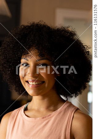 Biracial young woman smiling, wearing casual clothes at home 116131576
