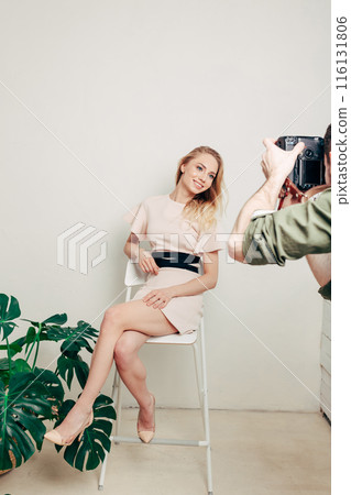 cheerful happy girl sitting on the chair and posing to the camera cheerful happy girl sitting on the chair and posing to the camera 116131806