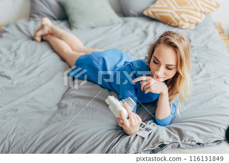 Sexy fair-haired woman with DLSR camera in the bed. Sexy fair-haired woman with DLSR camera in the bed. 116131849