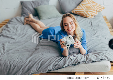 fair-haired girl is happy as she has made excellent photos 116131850