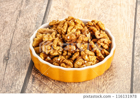 Cracked unshelled walnut in the bowl Cracked unshelled walnut in the bowl 116131978