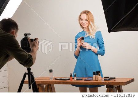 awesome blond girl holding a tonel cream and looking at the camera awesome blond girl holding a tonel cream and looking at the camera 116132039