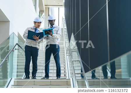 Group of multinational engineers having a conversation in a facility Group of multinational engineers having a conversation in a facility 116132372