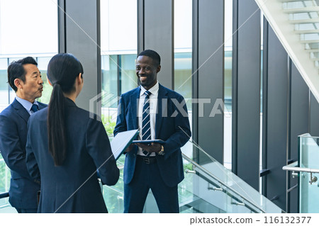 Group of multinational business people having a conversation in a lobby 116132377