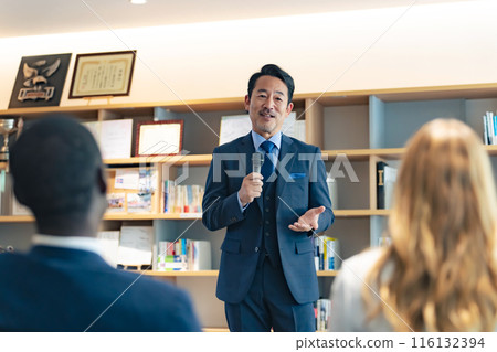 A middle-aged man giving a speech in the lobby 116132394
