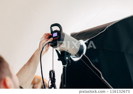 young man preparing the device for photo session young man preparing the device for photo session 116132673