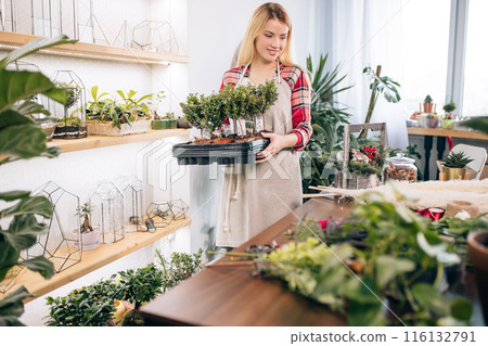 careful lady in her own florist shop 116132791