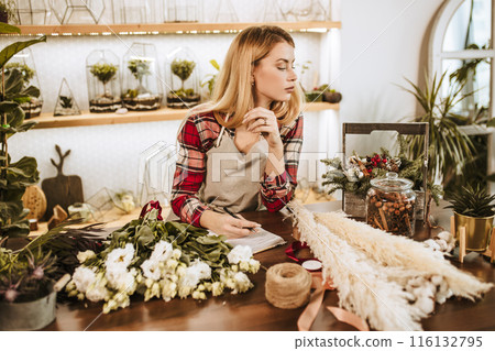 young lady florist make notes at work young lady florist make notes at work 116132795