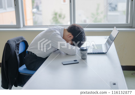 Businessman lying down on desk 116132877