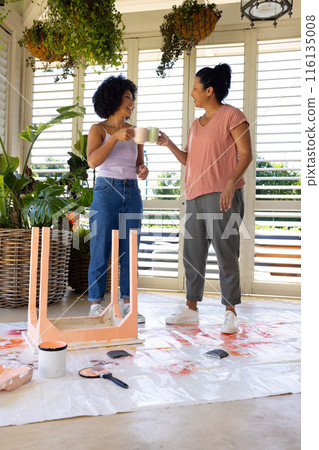 Biracial mother and adult adult daughter enjoying coffee during home painting and upcycling project Biracial mother and adult adult daughter enjoying coffee during home painting and upcycling project 116135008