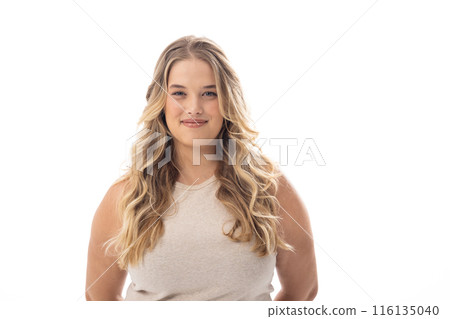 Young caucasian female plus size model standing on white background, wearing sleeveless top, smiling Young caucasian female plus size model standing on white background, wearing sleeveless top, smiling 116135040