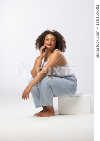 Biracial young female plus size model posing on white background, wearing casual clothes, copy space 116135082