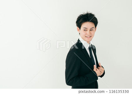 A handsome businessman in his 20s standing with a smile A handsome businessman in his 20s standing with a smile 116135330