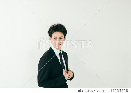 A handsome businessman in his 20s standing with a smile 116135338