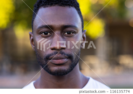 African American young male athlete standing on a field, looking directly at the camera, copy space 116135774