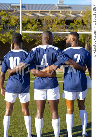 Three African American young male athletes in blue jerseys, white shorts on field outdoors Three African American young male athletes in blue jerseys, white shorts on field outdoors 116135867