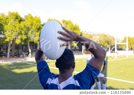 Group of three African American young male athletes training with a rugby ball on a field outdoors Group of three African American young male athletes training with a rugby ball on a field outdoors 116135890