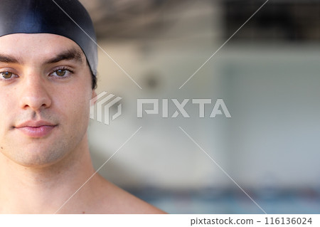 Caucasian young male swimmer indoors, wearing a black cap, looking at the camera, copy space Caucasian young male swimmer indoors, wearing a black cap, looking at the camera, copy space 116136024