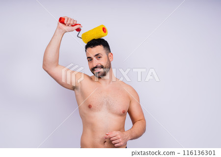 Young employee handyman using paint roller hold face isolated on background studio. Young employee handyman using paint roller hold face isolated on background studio. 116136301