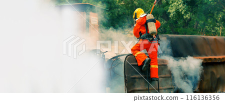 Firefighter Rescue training in fire fighting extinguisher. Firefighter fighting with flame using fire hose chemical water foam spray engine. Fireman wear hard hat, safety suit uniform for protection Firefighter Rescue training in fire fighting extinguisher. Firefighter fighting with flame using fire hose chemical water foam spray engine. Fireman wear hard hat, safety suit uniform for protection 116136356