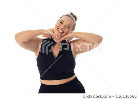 Caucasian young female plus size model poses with hands under chin, smiling, copy space 116136566