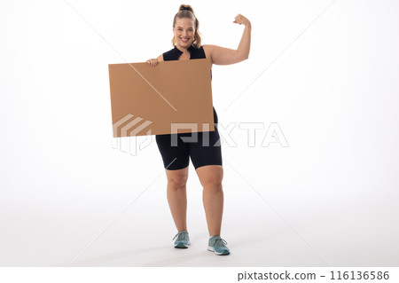 A Caucasian plus-size model with white background holds a sign, copy space A Caucasian plus-size model with white background holds a sign, copy space 116136586