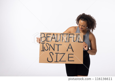 Biracial young female plus size model holds poster on a white background 116136611