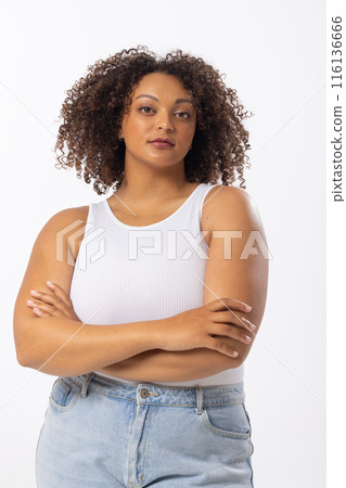 Biracial plus size model stands with arms crossed on white background 116136666