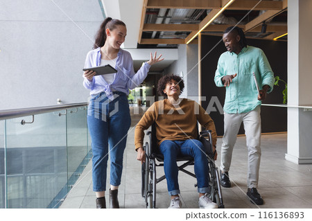 Diverse group of colleagues walking and talking in a modern business office hallway Diverse group of colleagues walking and talking in a modern business office hallway 116136893