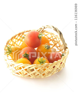 A bamboo basket full of yellow and red cherry tomatoes photographed on a white background A bamboo basket full of yellow and red cherry tomatoes photographed on a white background 116136989
