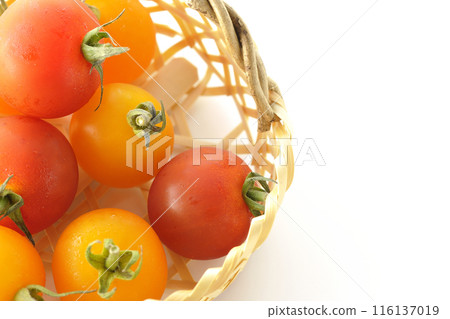A bamboo basket full of yellow and red cherry tomatoes photographed on a white background A bamboo basket full of yellow and red cherry tomatoes photographed on a white background 116137019