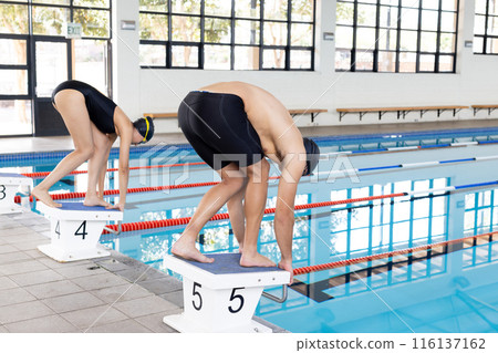 Biracial girl and Caucasian boy, young swimmers, get ready to dive Biracial girl and Caucasian boy, young swimmers, get ready to dive 116137162