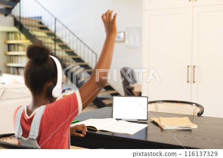 African American girl in headphones raises hand in tablet-based online lesson, copy space African American girl in headphones raises hand in tablet-based online lesson, copy space 116137329
