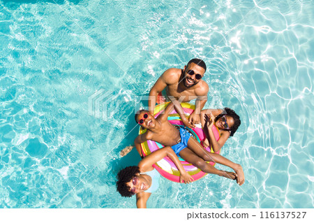 Diverse family enjoys a sunny day in the pool Diverse family enjoys a sunny day in the pool 116137527