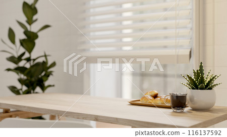 A minimalist wooden table or dining table near the window in a bright room. cafe, dining room A minimalist wooden table or dining table near the window in a bright room. cafe, dining room 116137592