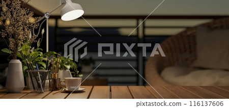A close-up image of a space on a wooden coffee tabletop on a home balcony in a nighttime. A close-up image of a space on a wooden coffee tabletop on a home balcony in a nighttime. 116137606