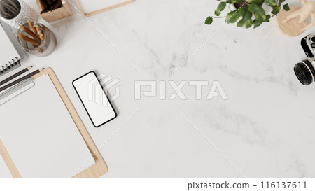 A white marble tabletop workspace features stationery, a smartphone mockup, and a copy space. A white marble tabletop workspace features stationery, a smartphone mockup, and a copy space. 116137611