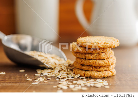 Tasty oatmeal cookies and rolled oat on wooden table. Tasty oatmeal cookies and rolled oat on wooden table. 116137632