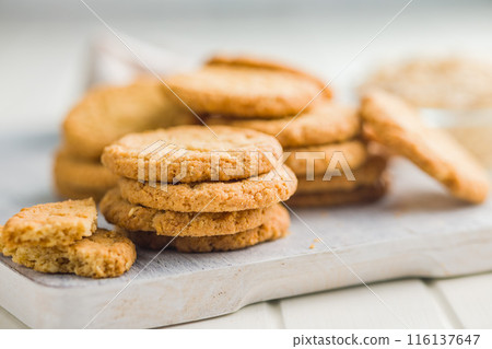 Tasty oatmeal cookies on cutting board on white table. 116137647