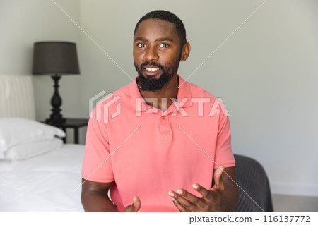 African American man sitting, talking with hands at home during a video call African American man sitting, talking with hands at home during a video call 116137772