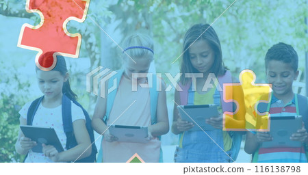 Image of colourful puzzle pieces over school children using tablets 116138798