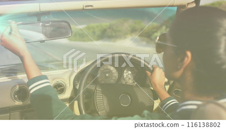 Image of biracial woman wearing glasses, driving a cabriolet 116138802