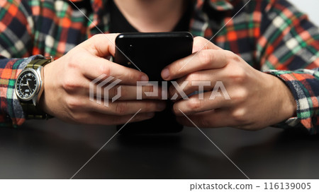 Man holding phone close up. Banner for design. Businessman looking at his phone for time management, with a professional design backdrop Man holding phone close up. Banner for design. Businessman looking at his phone for time management, with a professional design backdrop 116139005