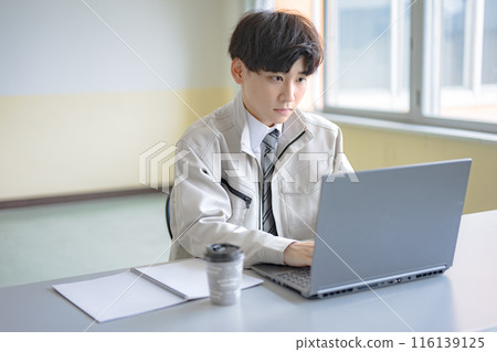 穿著工作服的年輕人在電腦上打字 116139125