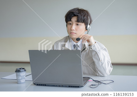 A young man in work clothes wearing an intercom A young man in work clothes wearing an intercom 116139153