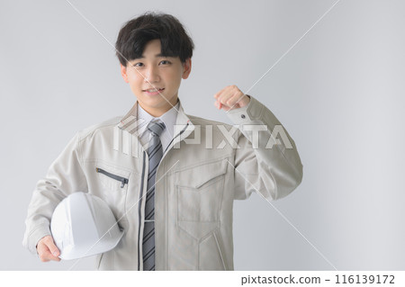 Young man in work clothes with helmet Young man in work clothes with helmet 116139172