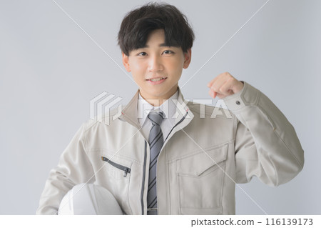 Young man in work clothes with helmet Young man in work clothes with helmet 116139173
