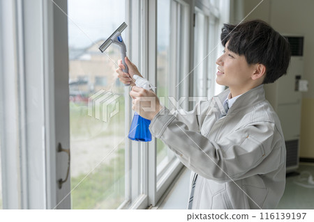 一個穿著工作服清潔窗戶的男人 116139197