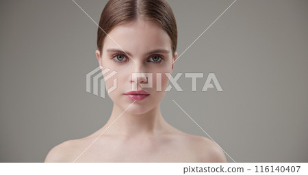 Beauty, health, cosmetics, anti-aging therapy and skin care concept - young beautiful brunette Caucasian woman looking at the camera, closing and opening her eyes 116140407